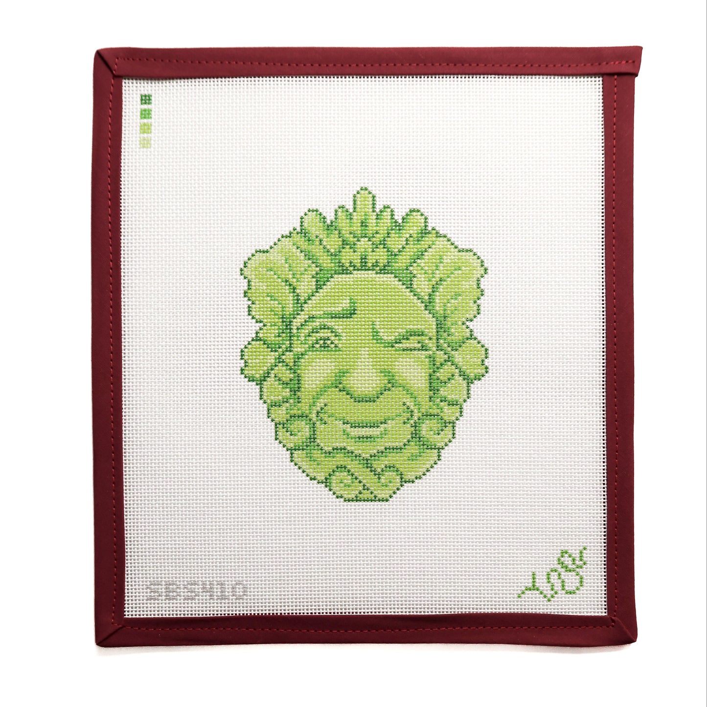 Green face on white fabric with burgundy bias tape border