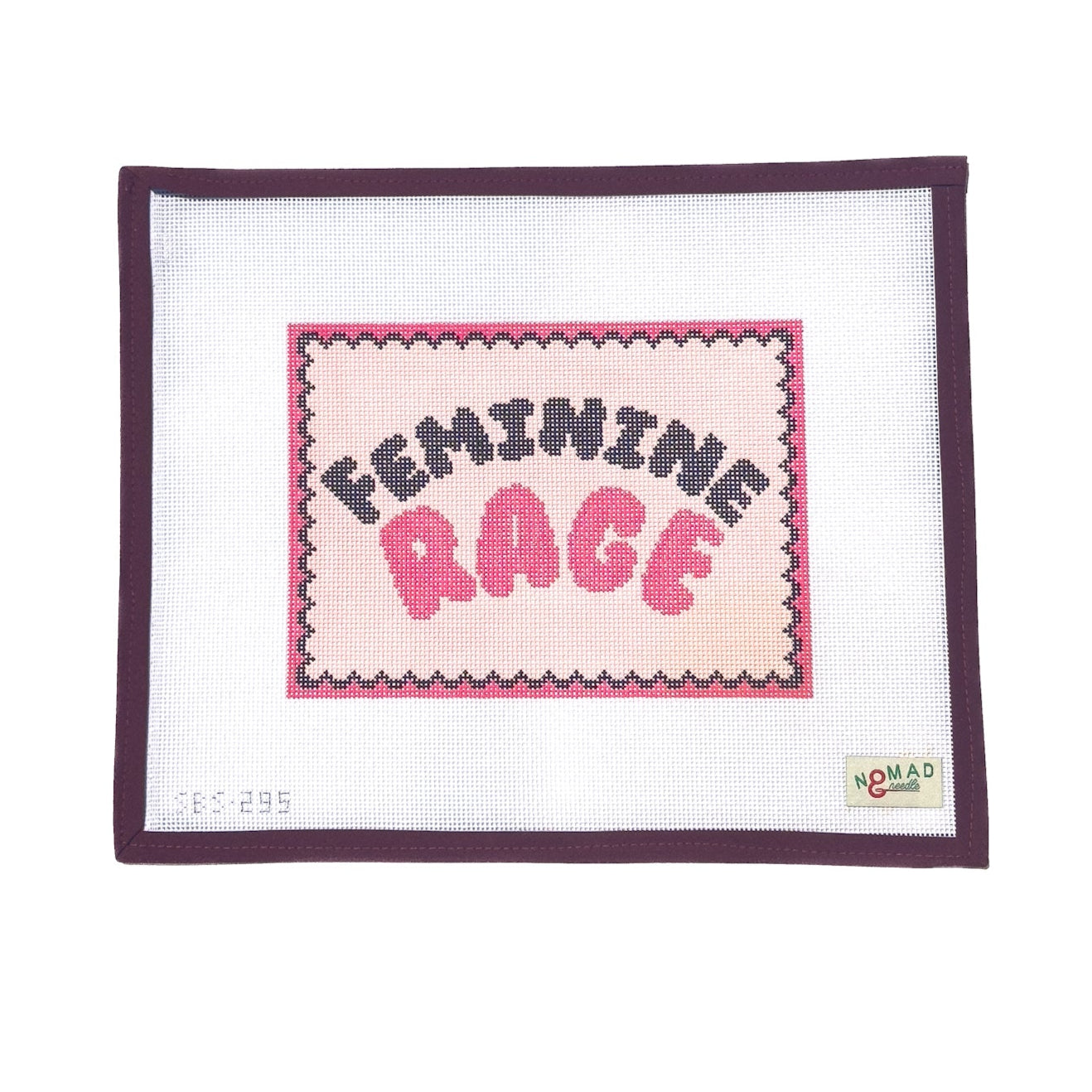 Hand-painted needlepoint canvas featuring bold bubble lettering that reads “Feminine Rage” in pink and black, framed by a scalloped border, designed by Nomad & Needle.