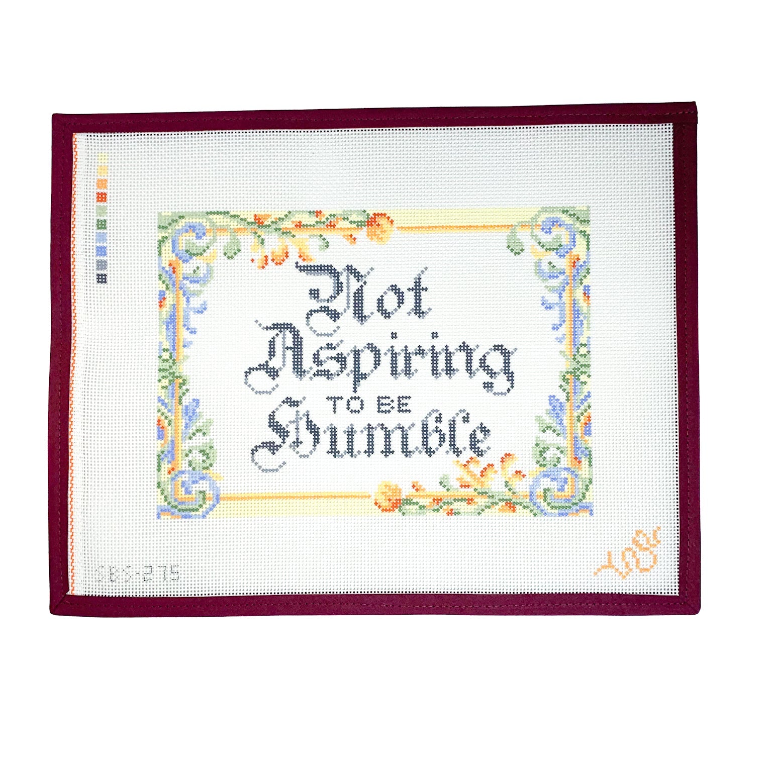Hand-painted needlepoint canvas featuring the phrase “Not Aspiring to Be Humble” in gothic calligraphy with an ornate floral border, shown in full view on white background.
